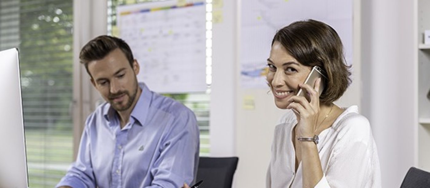 Žena s telefonem a projekt manažer u počítače.